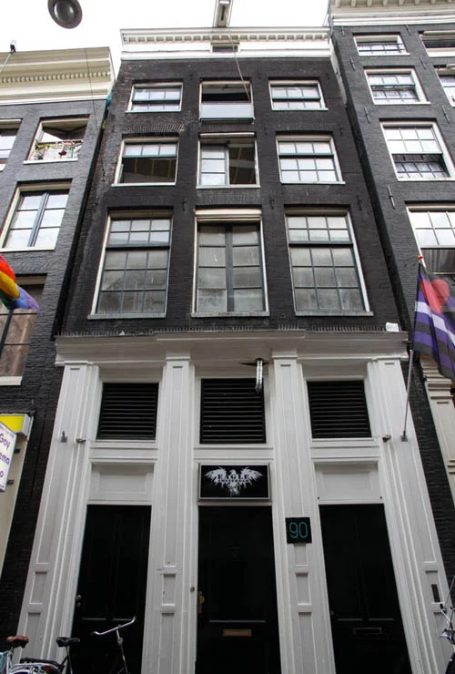 De 19e-eeuwse winkelgevel van Warmoesstraat 90 in Amsterdam, die het verborgen middeleeuwse houtskelet uit circa 1485 verbergt