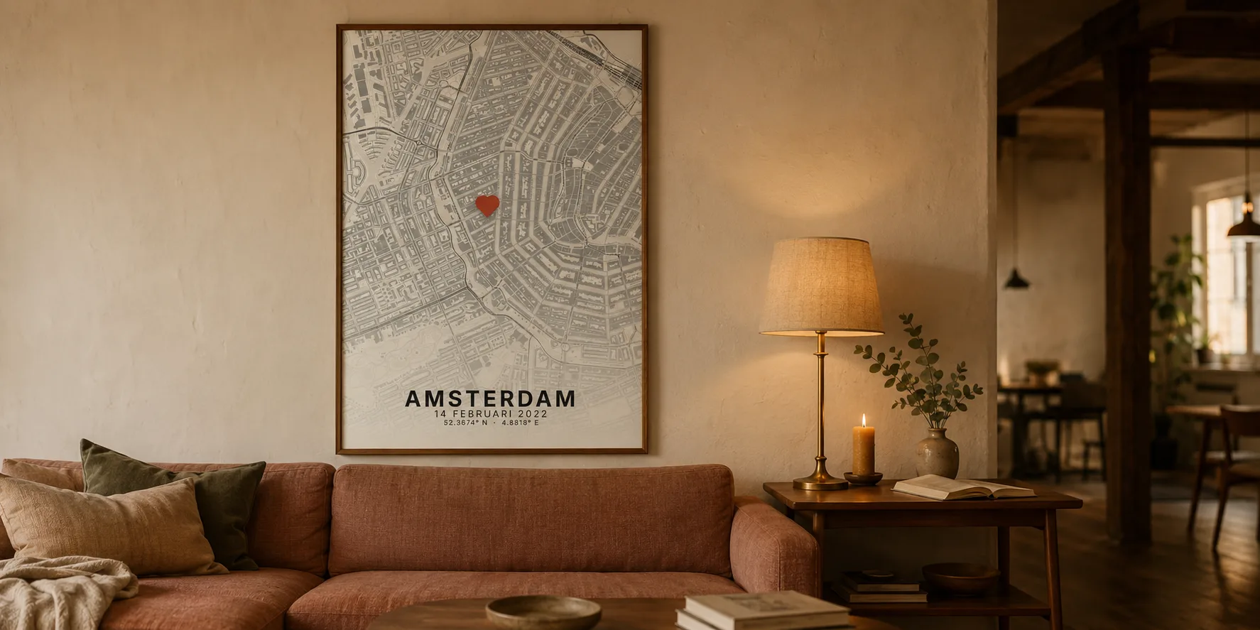 Ingelijste kaartposter van Amsterdam boven een bank in een woonkamer met warm avondlicht